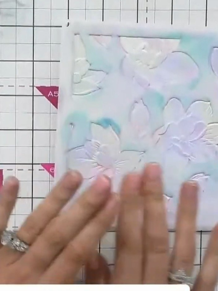 Step 2: Place a stencil over the embossed cardstock. Using your fingers or a blending tool, apply ink lightly through 