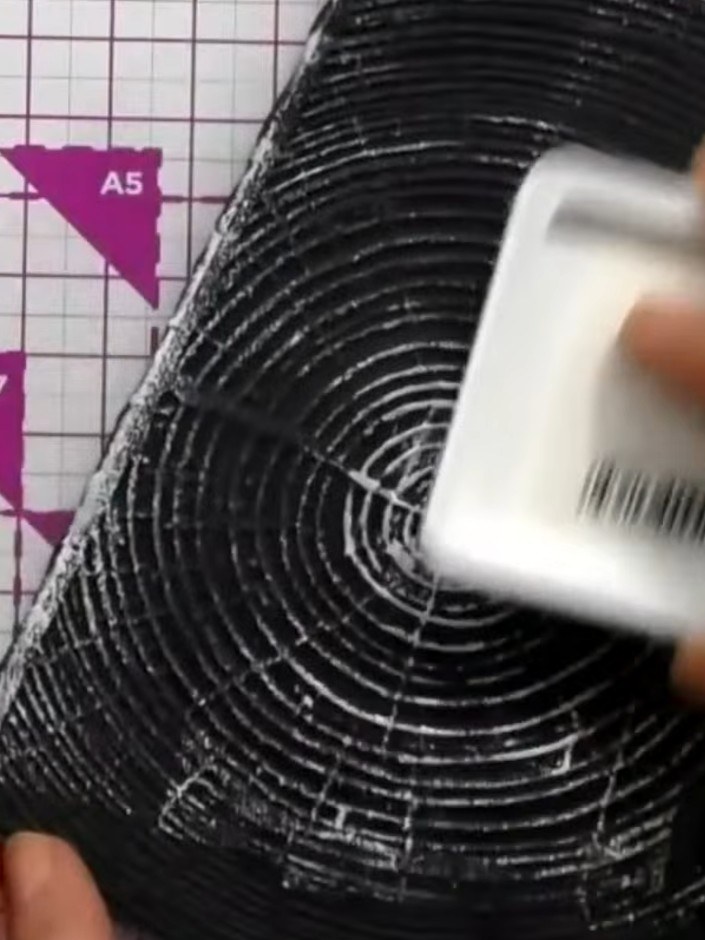 Step 5: Apply white ink to the embossed black card stock using an ink pad or dauber. Work the ink over the raised circ