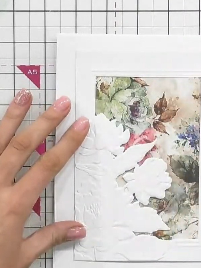Step 6: Adhere the complete embossed frame piece with the mounted floral topper onto your white card base, positioning