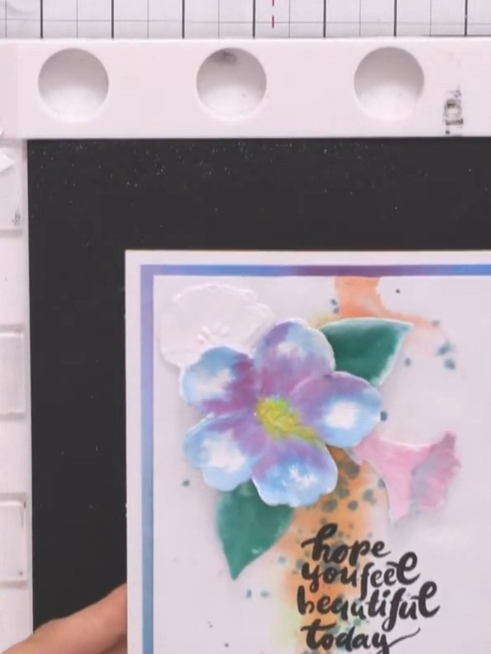 Step 11: Stamp a sentiment onto the card using black ink. Position the sentiment towards the bottom of the floral desig