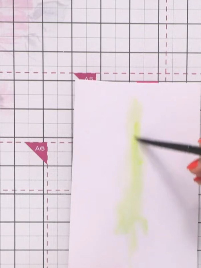 Step 8: Spray a piece of holographic cardstock with water. Drop yellow and orange ink into the centre of the wet surfa
