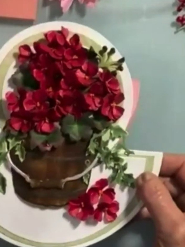 Step 15: Arrange foliage pieces, such as Ostrich fern die-cuts, around the base of the flower pot on the card front to 