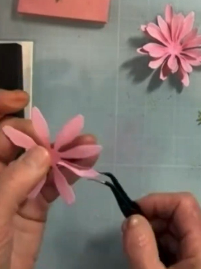 Step 3: Using tweezers, pinch the petals of the pink gerbera daisy to shape them. Mist the coloured petals lightly wit