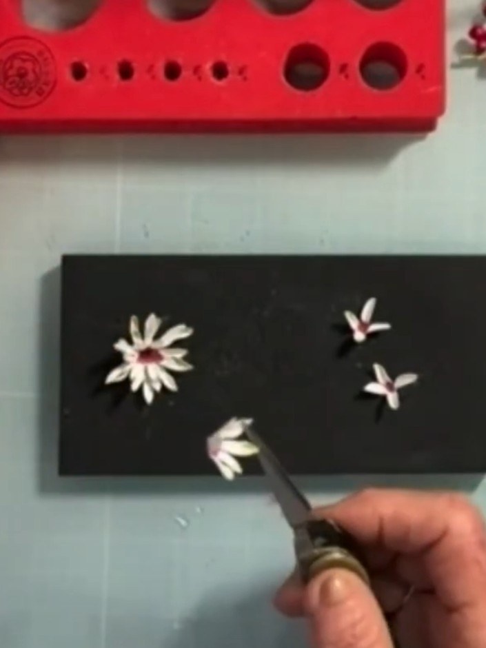 Step 5: Using tweezers, pinch each white petal close to the centre to create natural curves and dimension. Work around