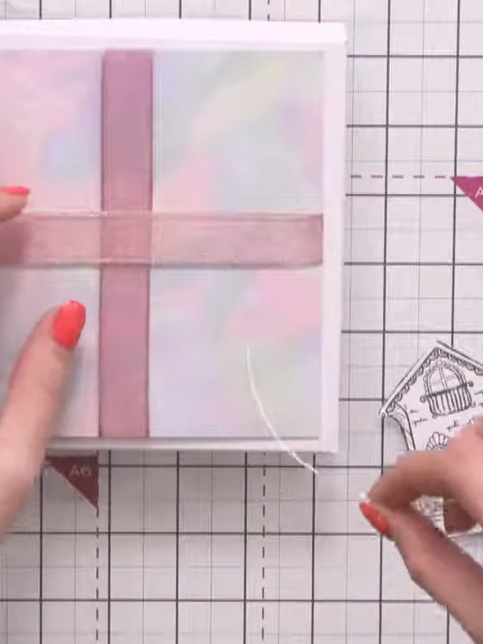 Step 3: Glue or tape the cotton string to the back of the fussy-cut design, positioning it under the centre of the des