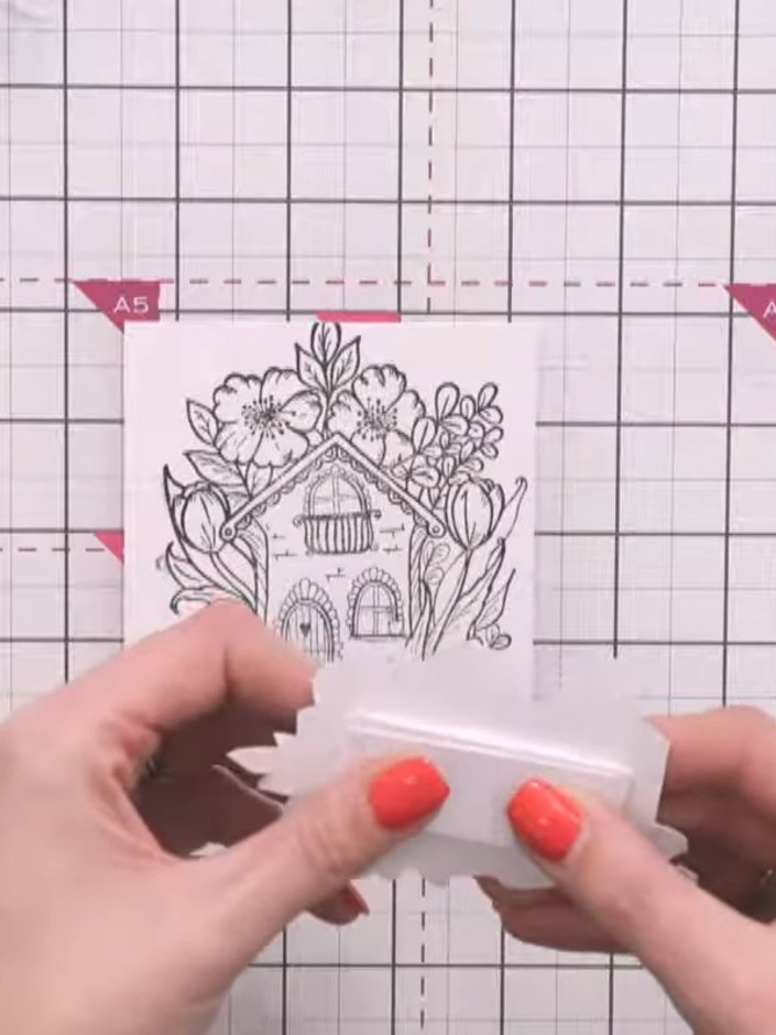 Step 5: Apply adhesive to the back of your padded house topper. Position and press it onto the centre of your card bas