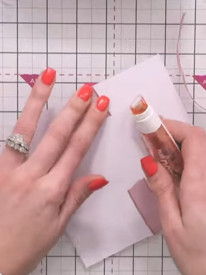 Step 4: Position the second ribbon vertically down the centre of the box, crossing over the first ribbon. Make sure it