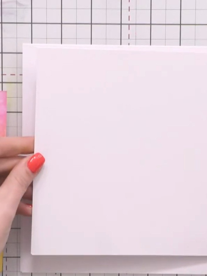 Step 1: Take your large white base card and apply adhesive to the back of your first white card layer using your adhes