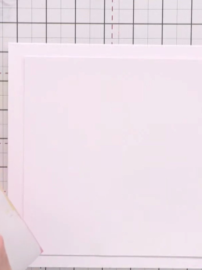 Step 2: Position the white layered card onto the card base. Use a piece of tissue or acetate to protect the surface an