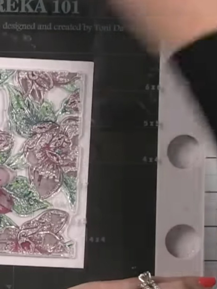 Step 8: Stamp the second part of the Quattro D stamp onto the card to complete the floral design. Ensure the stamp is 