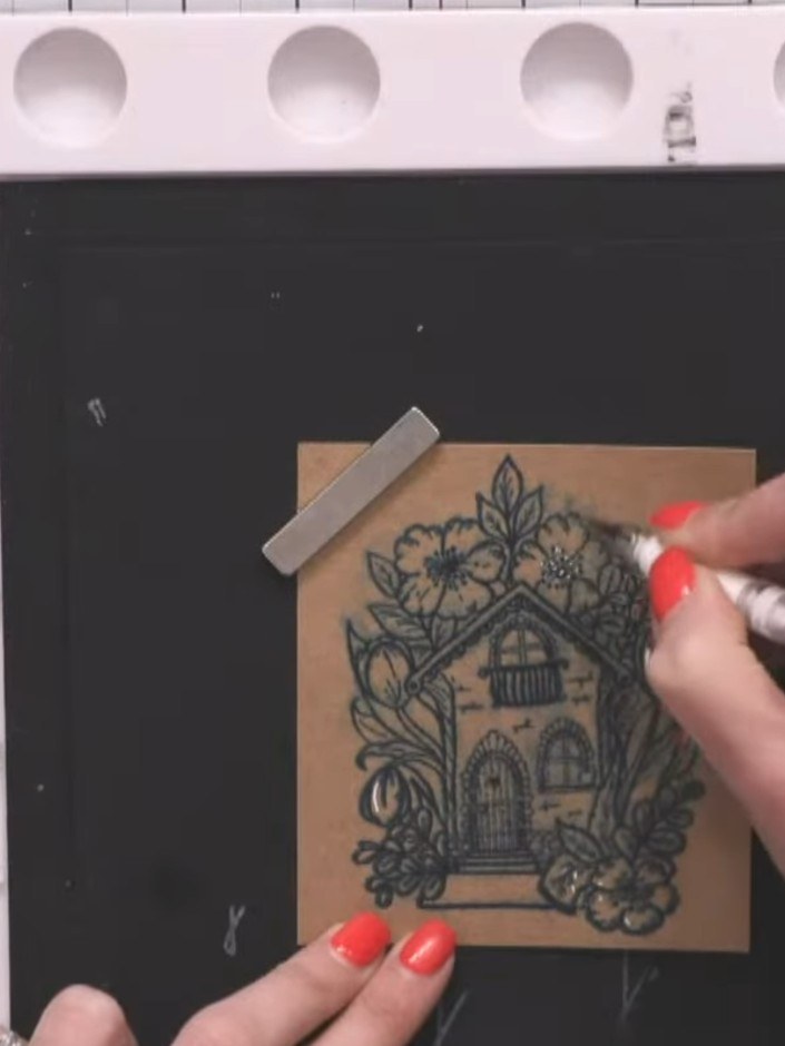 Step 5: Use a white gel pen to add fine detail to the stamped image. Draw small lines and dots on the flower petals an