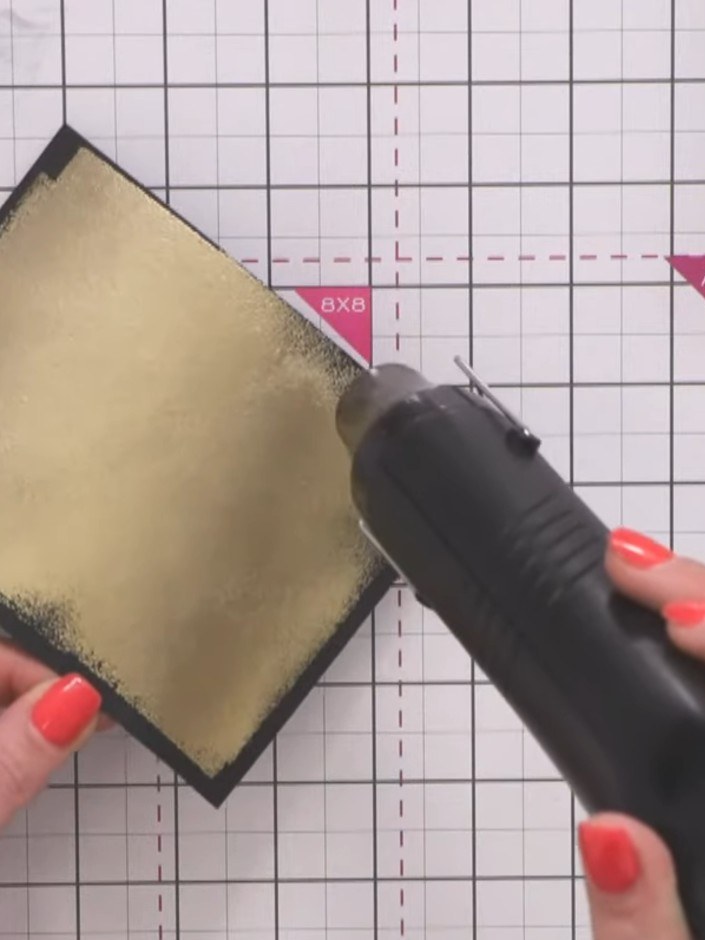 Step 10: Run the embossing folder with the inked black cardstock through your die-cutting machine using firm pressure t
