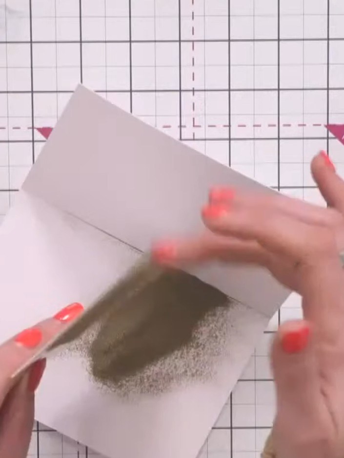 Step 7: Carefully tap off the excess embossing powder from the card panel back into the jar or onto a piece of scrap p