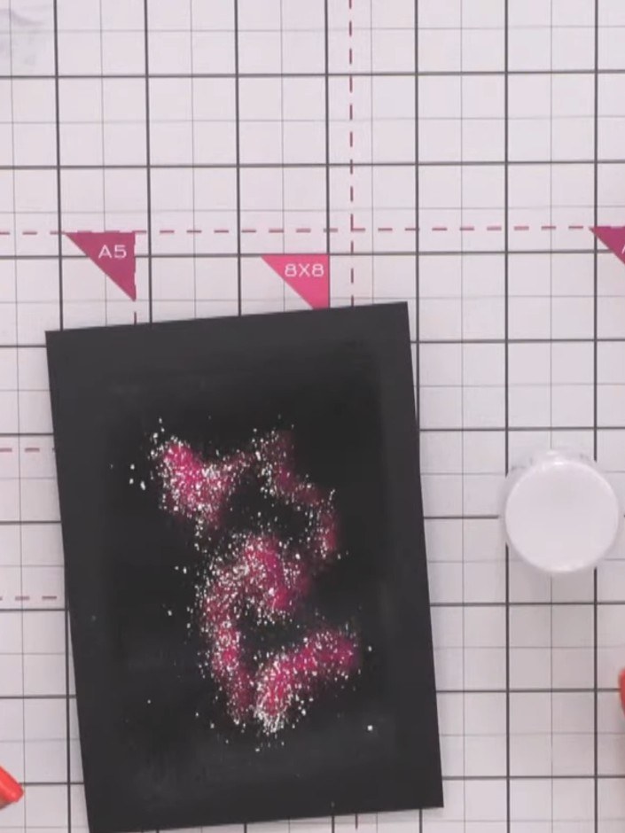 Step 6: Sprinkle coloured embossing powders in pink and teal over scattered areas of the inked surface, creating rando