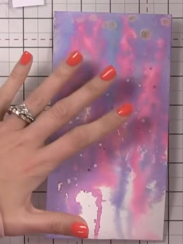 Step 1: Wet your galaxy-patterned card base with water using a spray bottle. Ensure the surface is evenly dampened bef