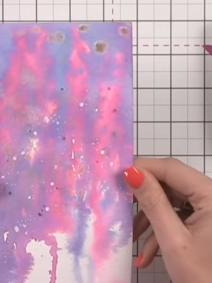 Step 5: Mientras el fondo todavía esté húmedo, salpica tinta blanca por toda la tarjeta para darle textura y hacerla más interesante.
