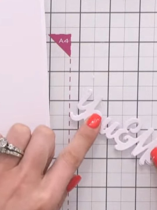 Step 10: Stack and glue the four white die-cut words together to create dimension, then glue the design-cut word on top