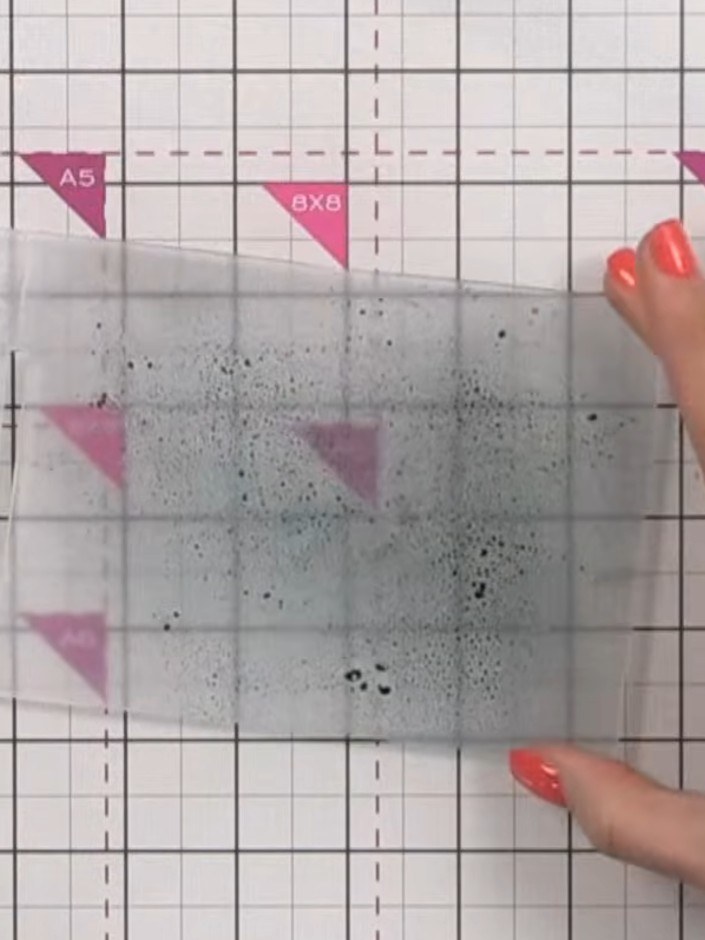 Step 2: Rocía la tinta en ambos lados de la carpeta de embossing desde cierta distancia para no saturarla demasiado. Ensure even co