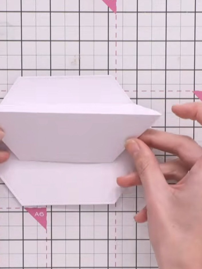 Step 5: Fold the second-largest shaped piece upwards and glue it to the front of the hinged section to create the stan