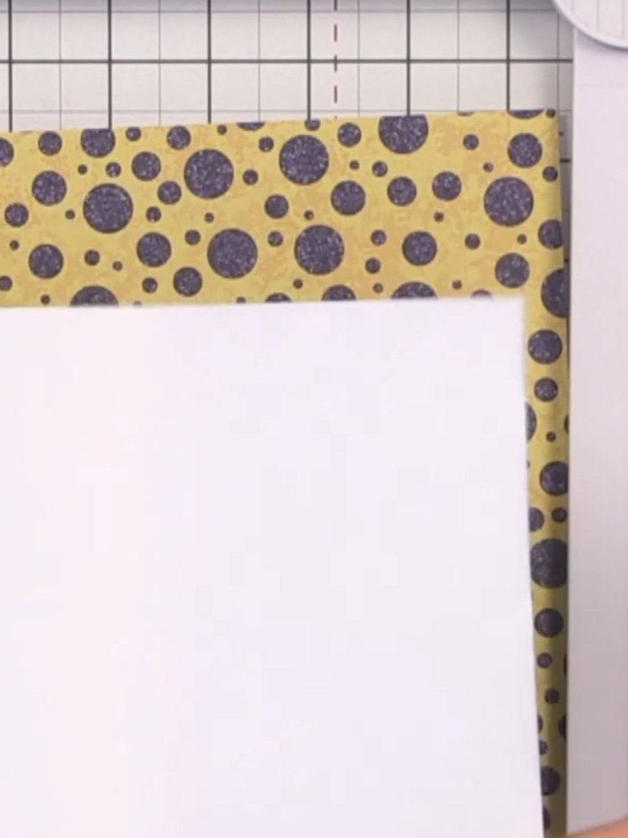 Step 1: Select an 8 by 8 inch piece of patterned paper for your front cover. Cut the paper in half at the 4-inch mark 