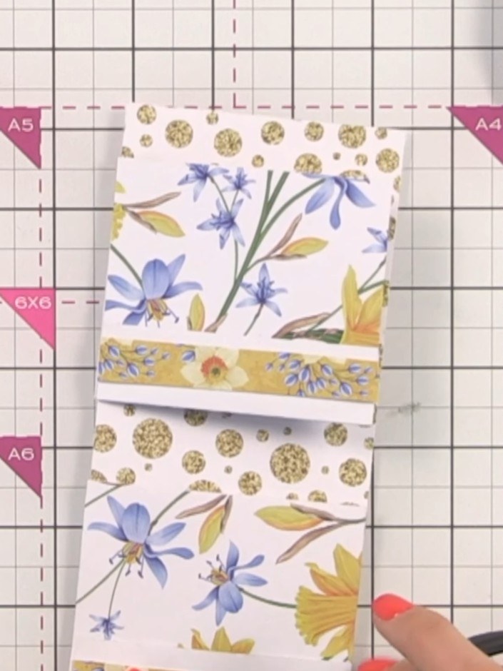 Step 13: Decorate the backs of the pockets using off-cut strips from your trimmed patterned papers. Glue the strips dow