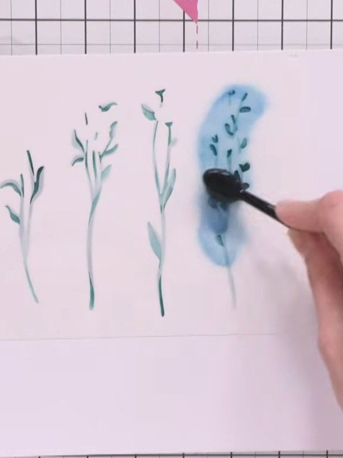 Step 2: Clean the stencil and position stencil number 2 over the card. Apply a slightly darker shade of green ink usin