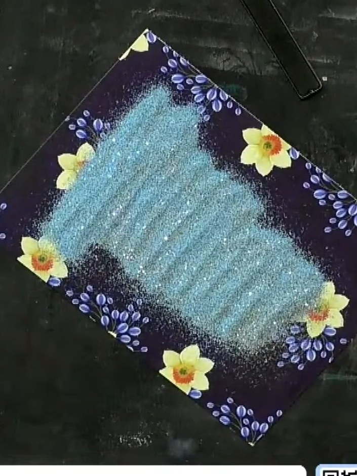 Step 7: Mount the embossed panel onto a contrasting card base. The teal embossed design sits on the dark navy floral p
