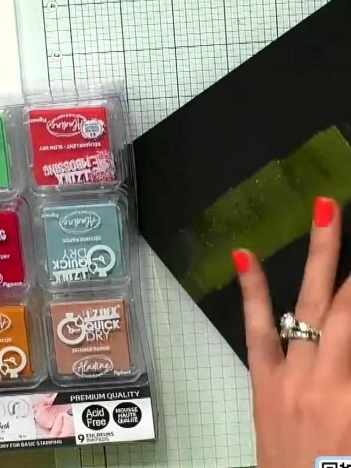 Step 1: Prepare a piece of black card stock as your base. Apply green ink across the card using an ink pad, creating a