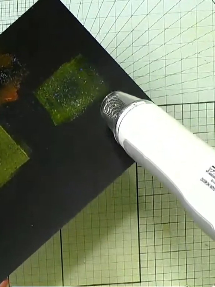 Step 3: Using a heat tool, carefully heat set the embossing powder on the black card. Move the heat tool over the surf
