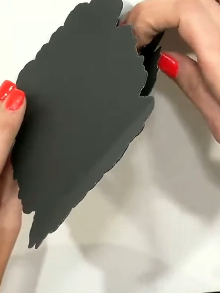 Step 3: Apply glue to the top section of the scored black card piece. Fold and adhere it to create a shaped card base 