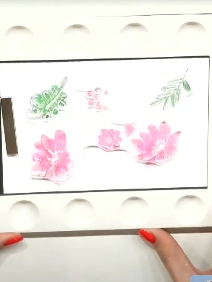 Step 6: Once all four stamped flower images are layered on your card front, position the coordinating plate die over t