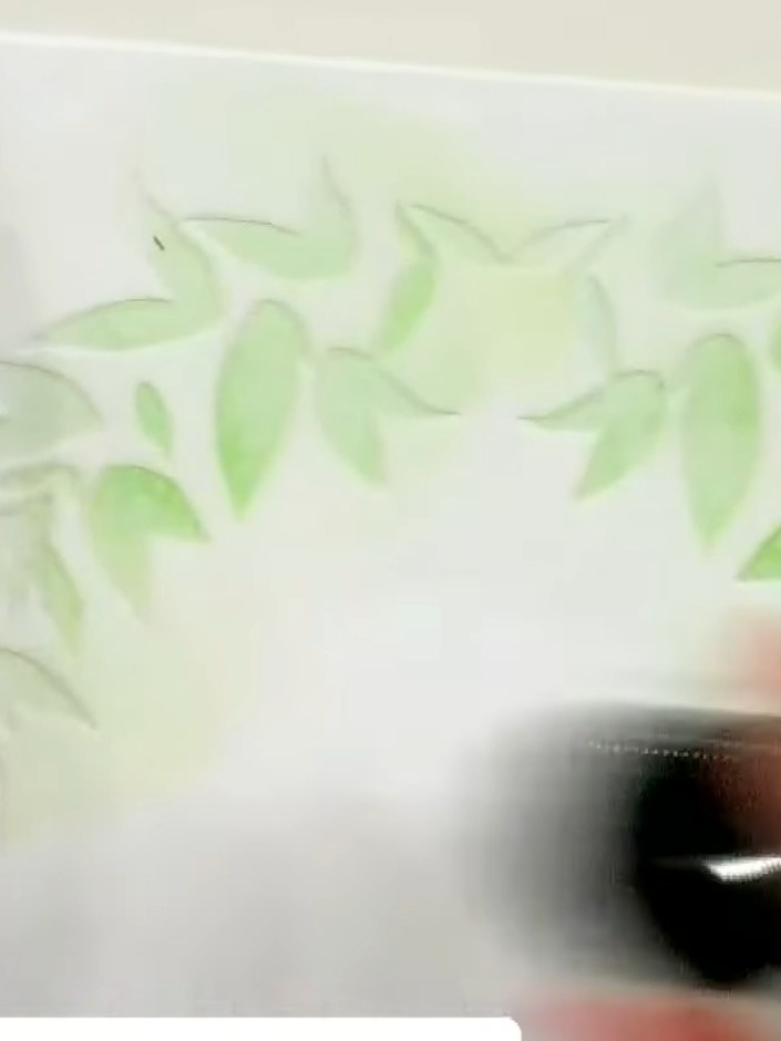 Step 4: Apply a darker green ink through the second stencil, pressing slightly harder to create dimension and depth in