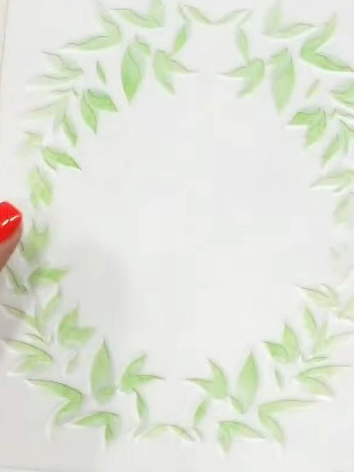 Step 6: Position stencil layer four over the card and apply green ink to add the final layer of leaves, completing the