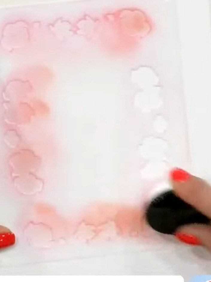 Step 1: Position your first stencil on white cardstock. Using a light orange ink pad, apply colour through the stencil