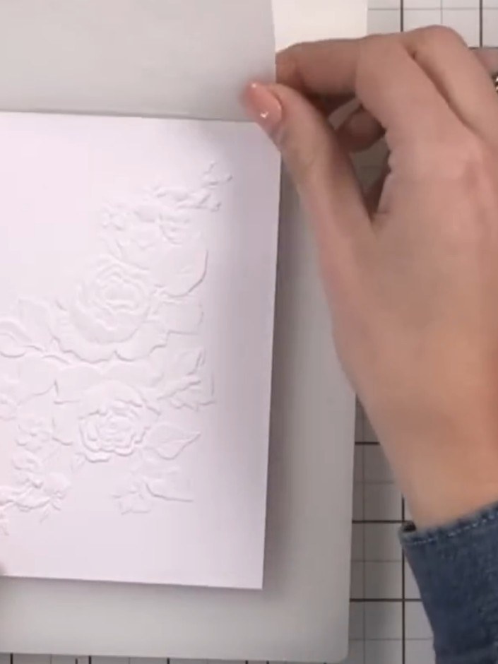 Step 2: Using black ink, lightly swatch over the embossed side of the white card to highlight the raised floral textur