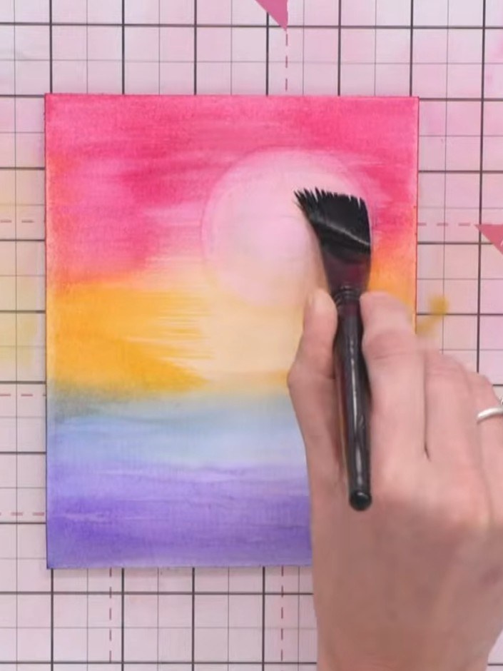 Step 8: Use a blending brush to gently apply darker ink pad colour around the outer edges of the rainbow gradient, bui