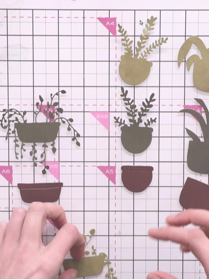 Step 5: Add small floral pieces to the top of the layered pots using glue. Position the delicate foliage and flower el