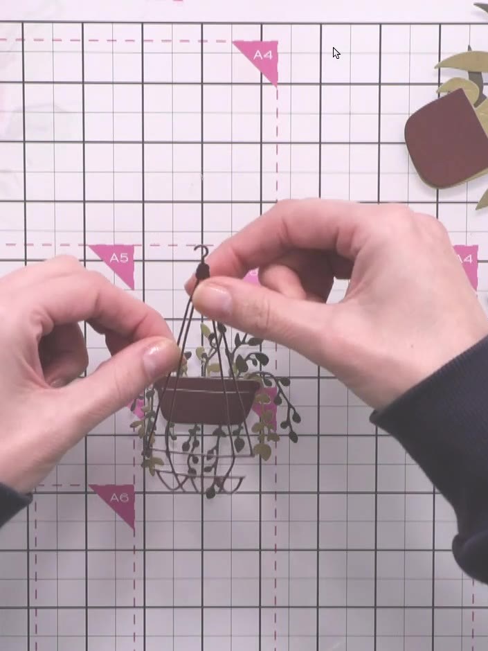 Step 5: Position the layered pot element inside the macramé basket opening, placing it centrally so it sits within the