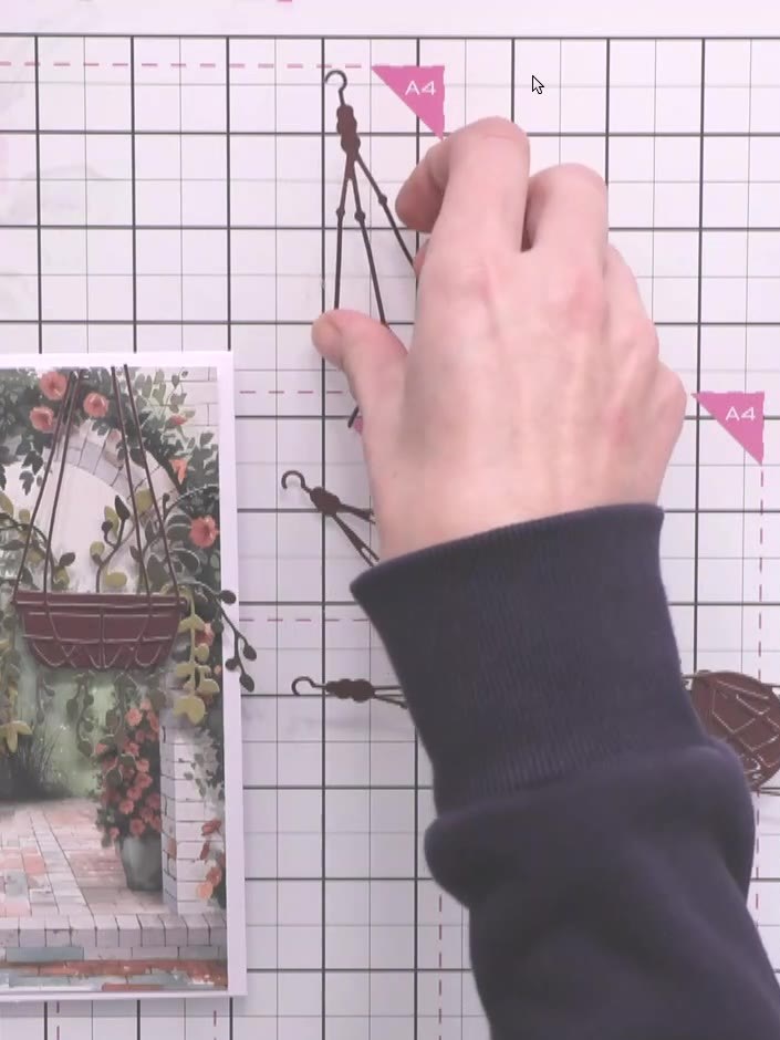 Step 6: Trim the top of the second hanging basket piece so it sits higher in the composition. Position it on the card 