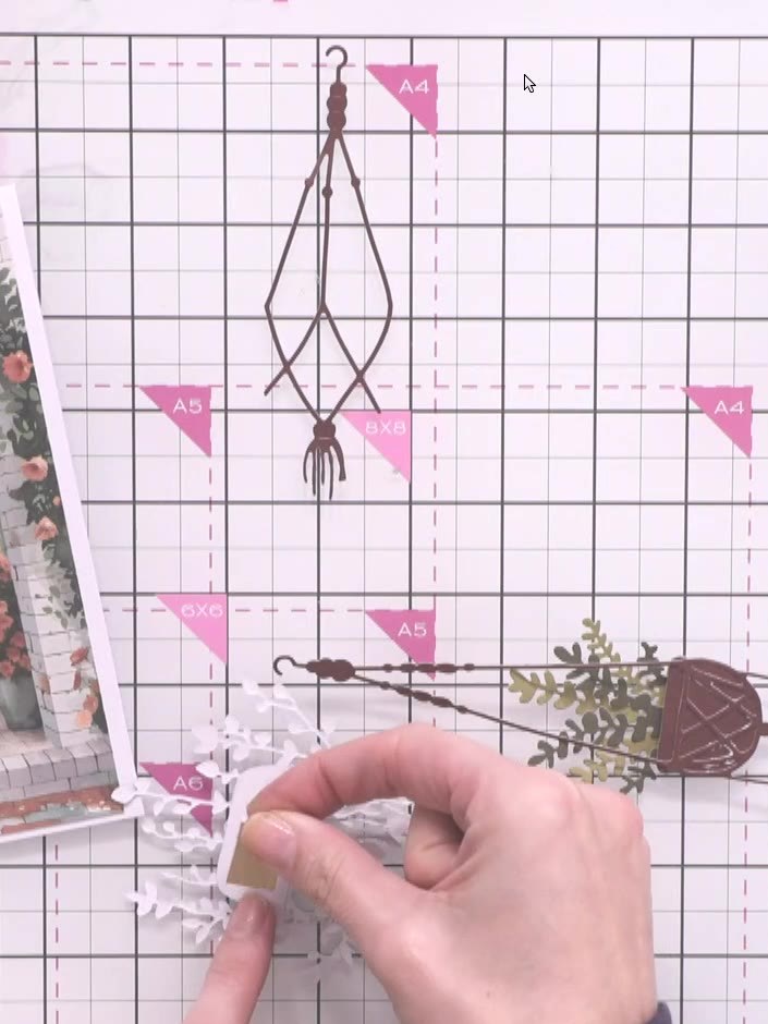 Step 8: Cut out a third hanging basket element. Position it at a different height on the card to create depth and pers