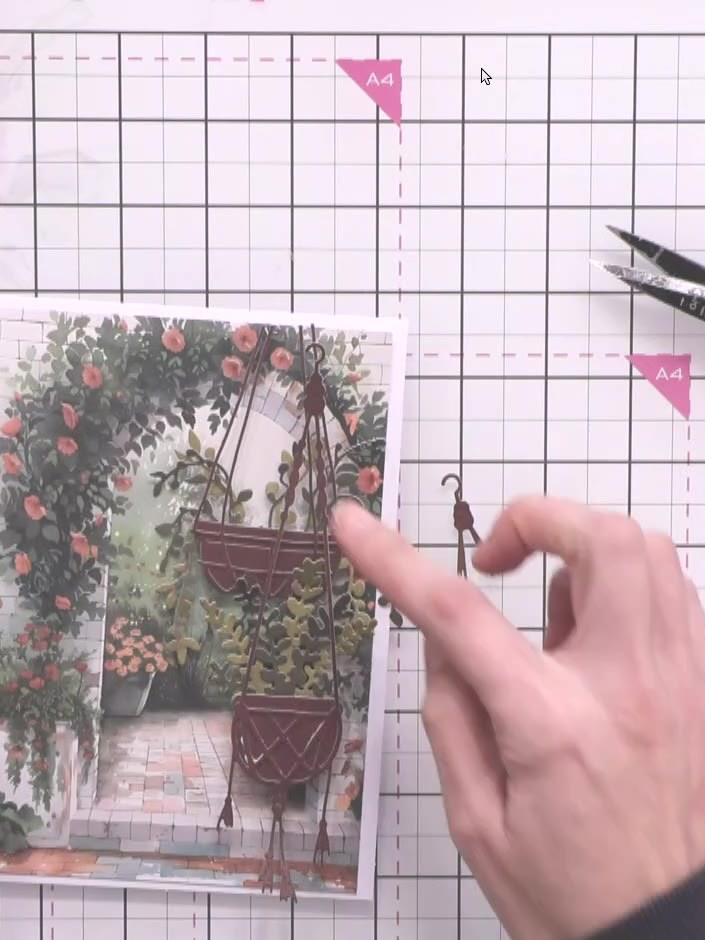 Step 9: Apply a small foam pad to the back of the third hanging basket. Position it on the card to raise it slightly a