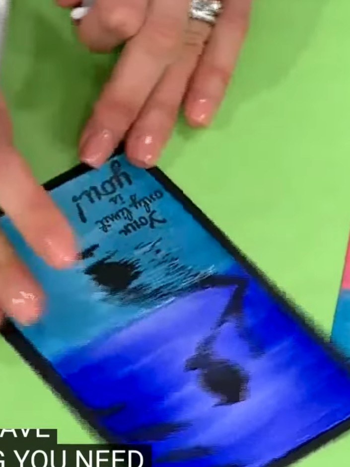 Step 1: Prepare your card base by selecting a piece of blue gradient cardstock. Smooth it flat on your work surface to