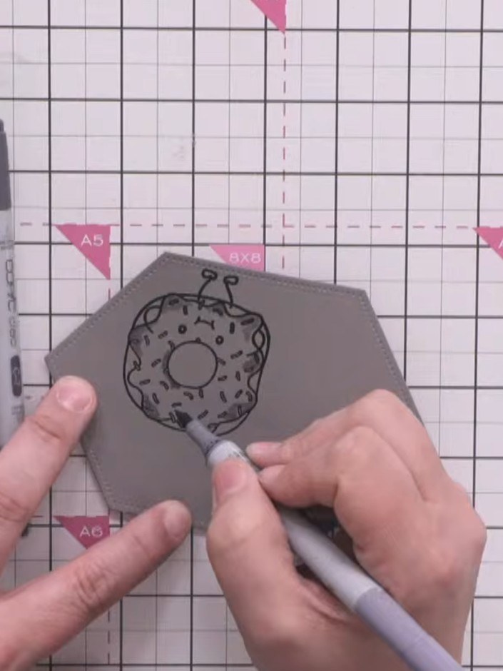 Step 6: Koloriere die Streusel auf dem Donut mit einem roten Alkoholmarker – das bringt tolle Farbakzente ins Design.