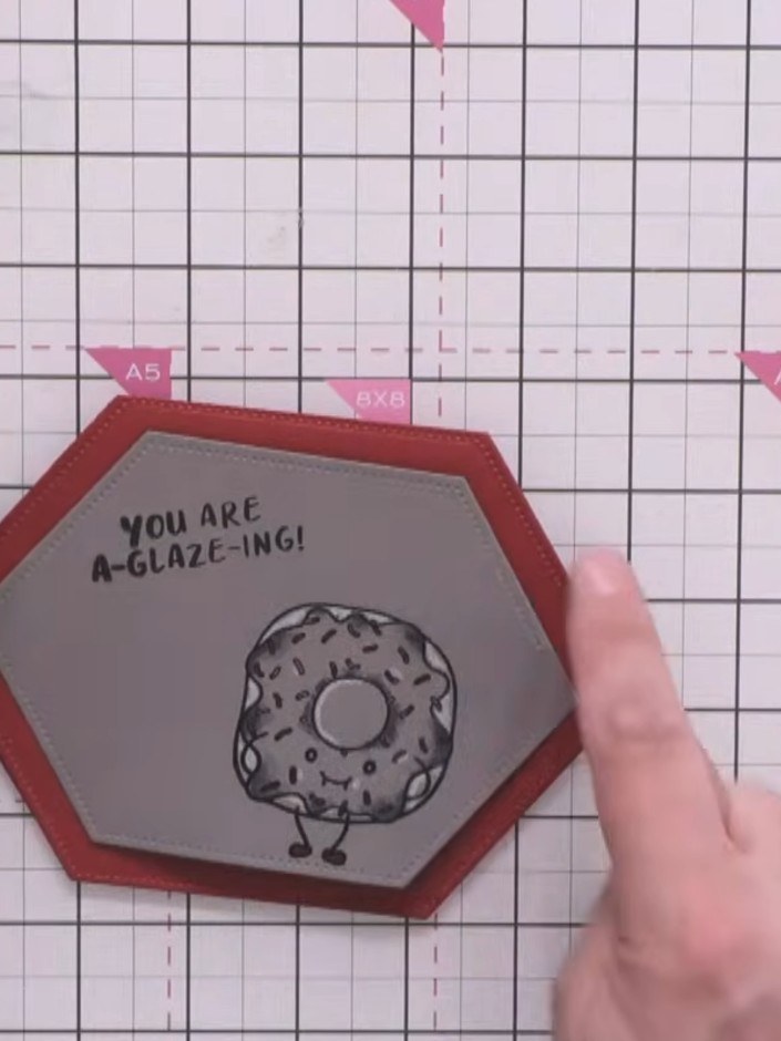 Step 9: Stamp a sentiment at the top of the grey hexagonal panel using the 'YOU ARE A-GLAZE-ING!' stamp from the Yum C