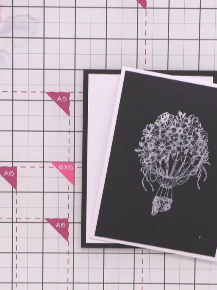 Step 6: Layer the die-cut hot air balloon and floral elements onto the embossed background panel using foam adhesive p