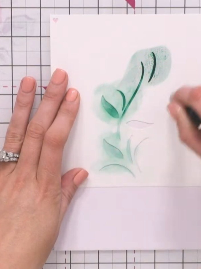 Step 6: Position stencil three (the leaves layer) on your card, lining up the registration hearts. Apply green ink thr