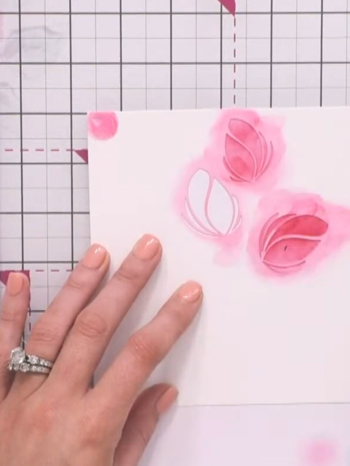 Step 9: After inking stencil one, lightly mist the inked area with water from a spray bottle. Allow the pink ink to bl