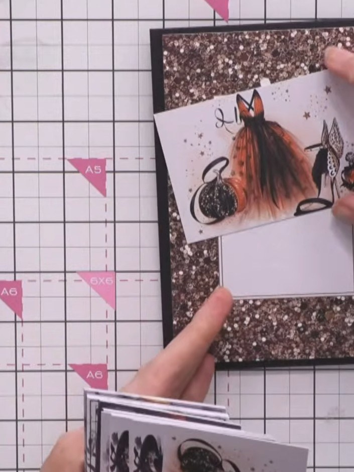Step 2: Setze den ersten Topper mit Abstandspads auf die schwarze Kartenmatte. Platziere ihn schön mittig auf dem Glitzerrahmen.