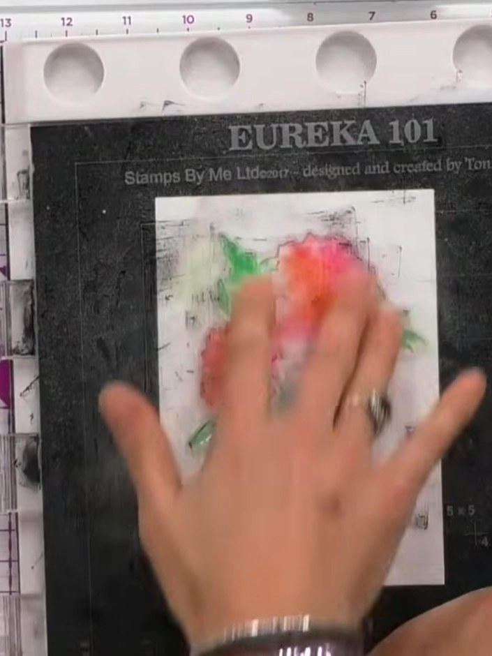 Step 2: Spray the inked stamp with water from a spray bottle to activate the inks and create a puddle effect on the wh