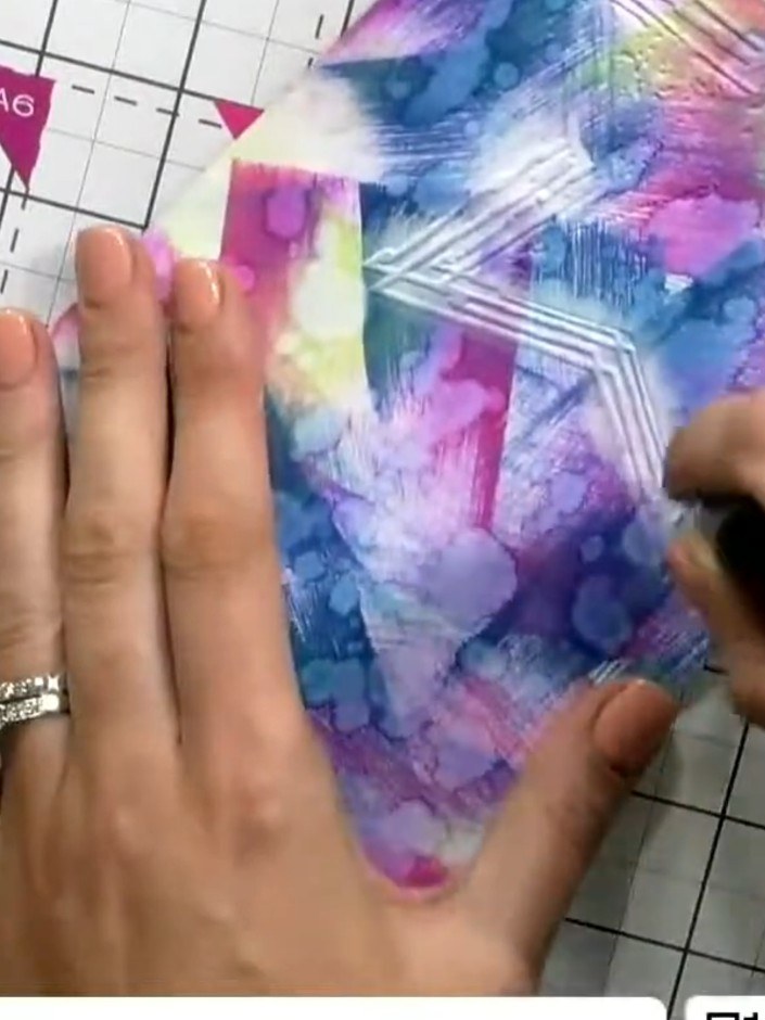 Step 6: Using a small detail brush, apply white ink to highlight the embossed star pattern. Work carefully over the ra